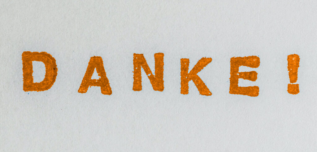 "Danke!" in orange auf Papier gestempelt